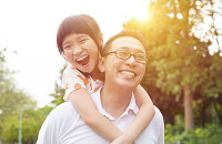 Father and daughter joyfully enjoying a sunny day outdoors.